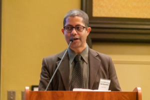 a man standing at a podium with a microphone