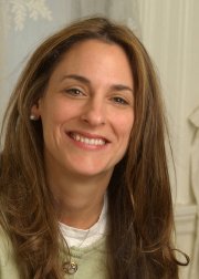 a woman with long brown hair smiling at the camera