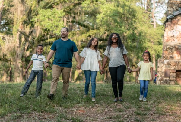 a group of people holding hands and walking in a field