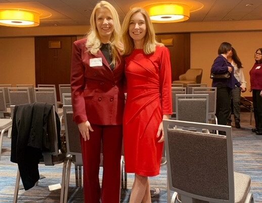 two women standing next to each other in a room