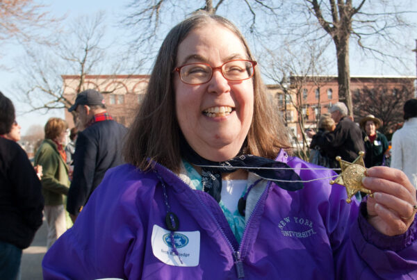 a woman in a purple jacket holding a cup of coffee