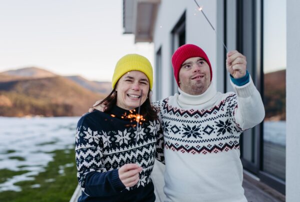 a man and a woman standing next to each other holding sparklers