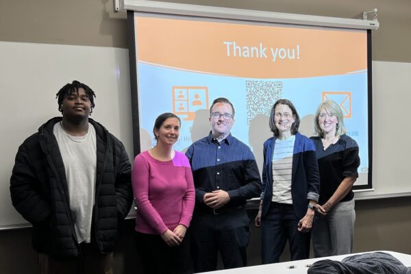 a group of people standing in front of a projector screen