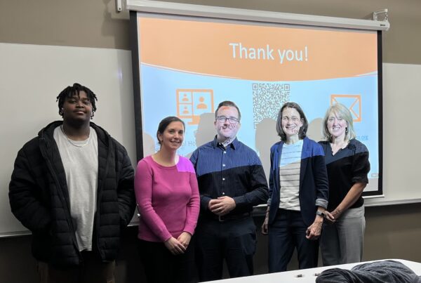 a group of people standing in front of a projector screen