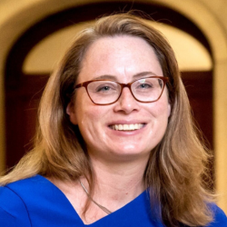 a woman wearing glasses and a blue shirt