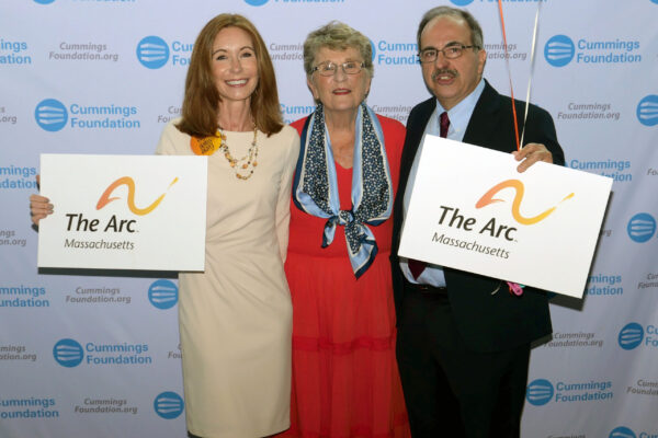 a group of people standing next to each other holding signs