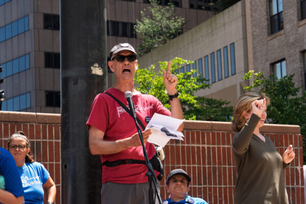 a man speaking into a microphone while standing next to a woman
