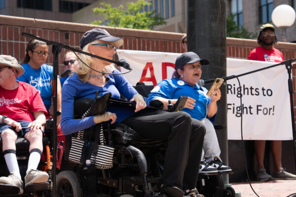 a woman sitting in a wheel chair with a microphone