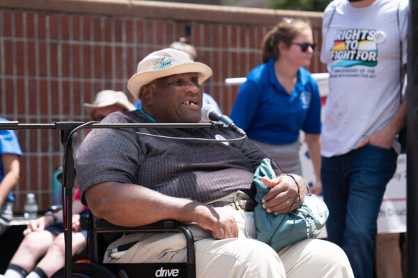 a man sitting in a wheel chair in front of a group of people
