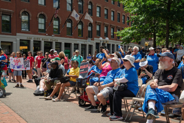 a crowd of people sitting on top of a sidewalk