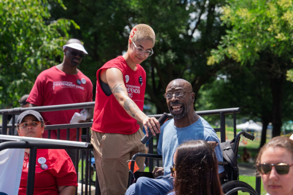 a man in a wheelchair talking to a group of people