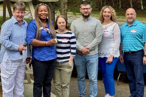 a group of people standing in front of a car