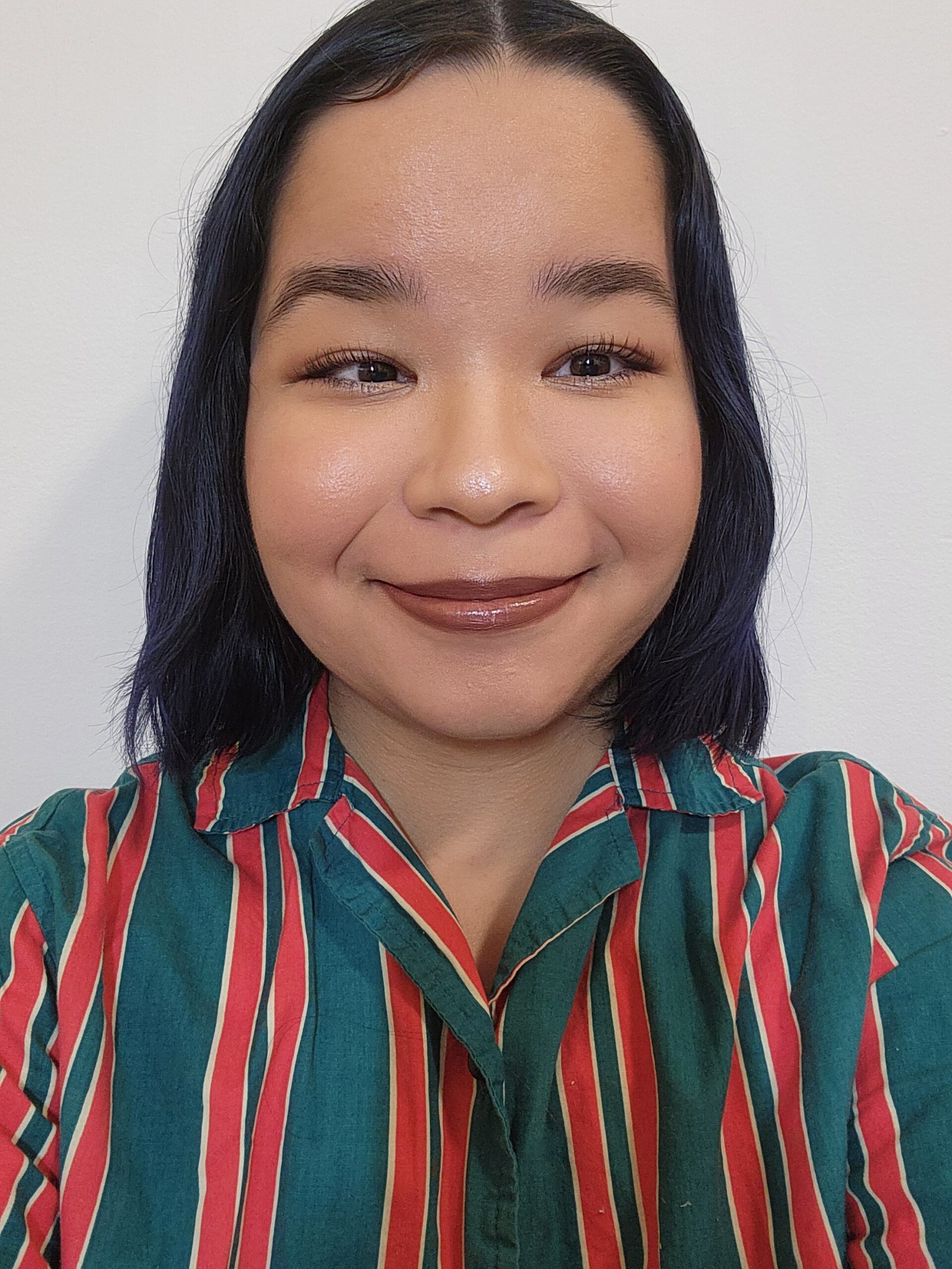a woman with black hair wearing a striped shirt