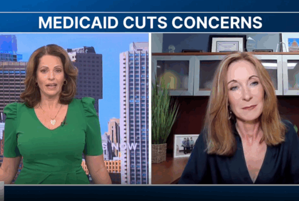 two women are on the news with a city in the background