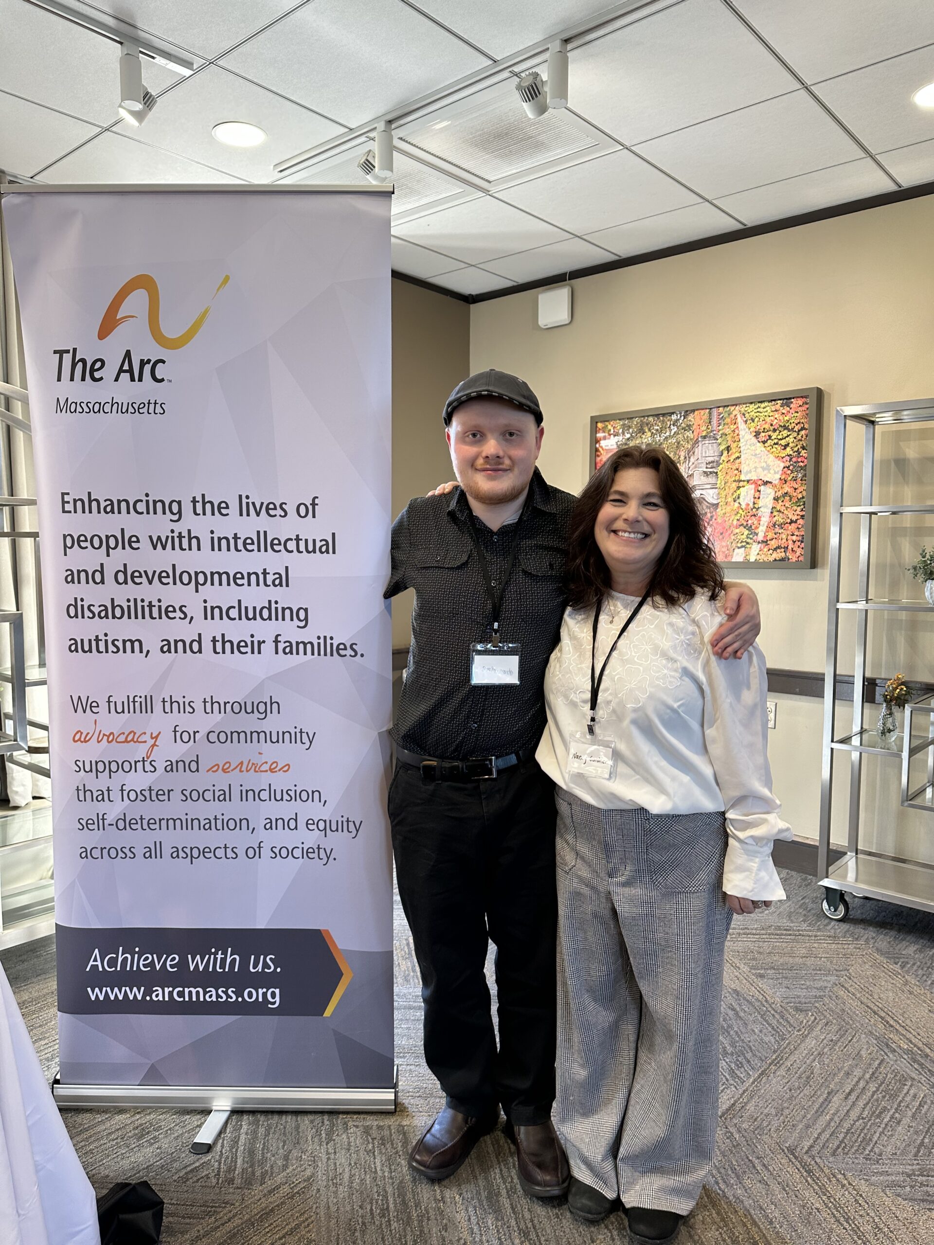 a couple of people standing next to a sign