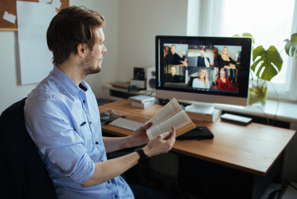 a man sitting at a desk reading a book