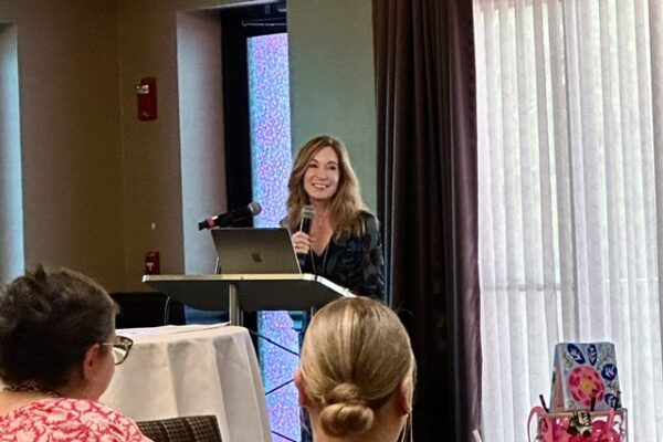 a woman standing at a podium giving a presentation