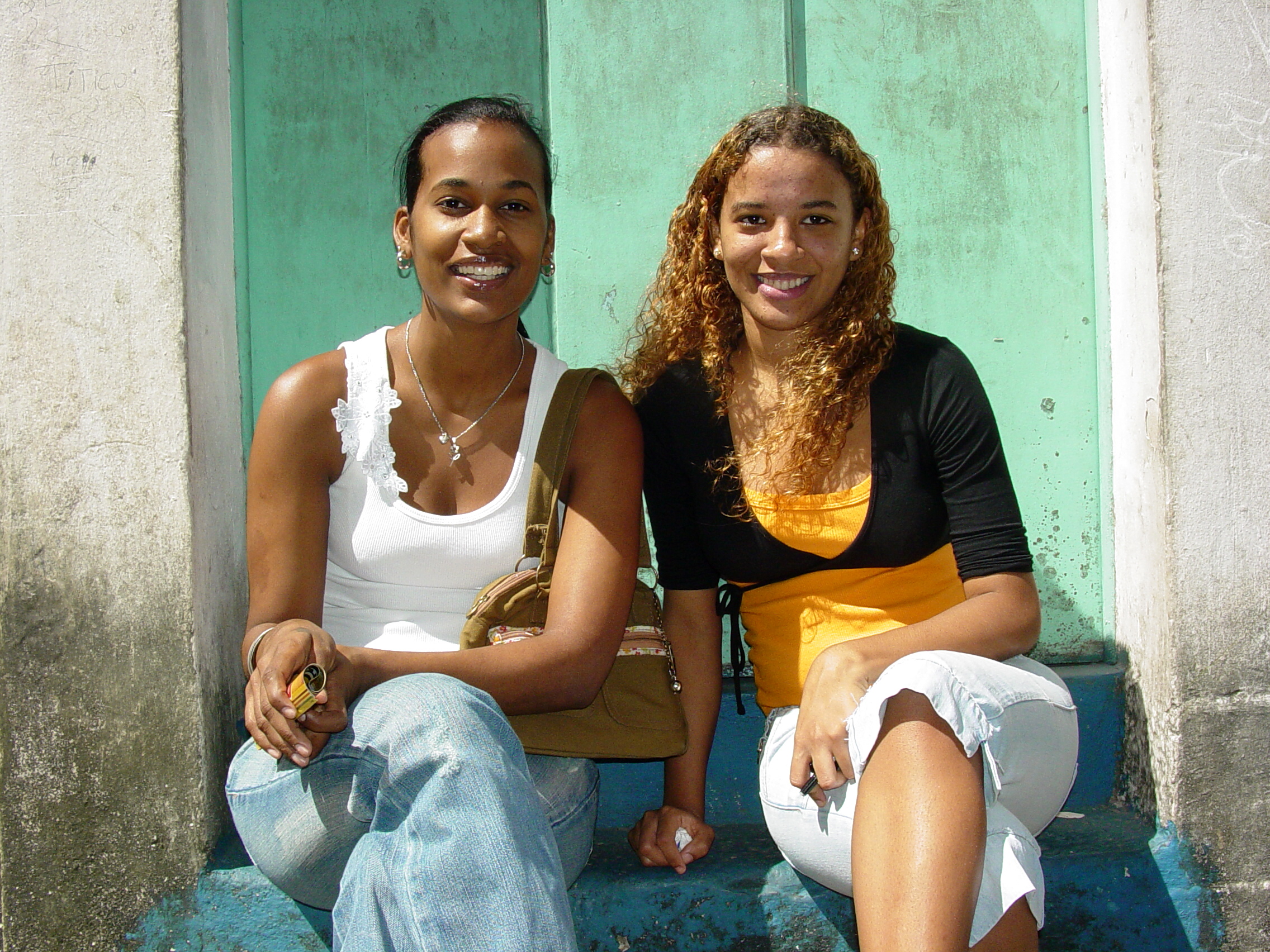 Two young women sitting on steps, smiling