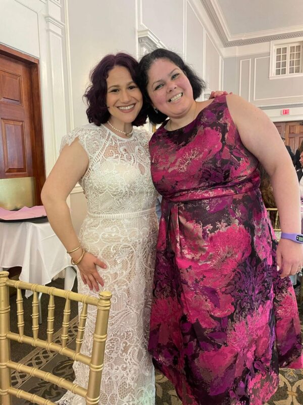 A bride and a guest smiling together
